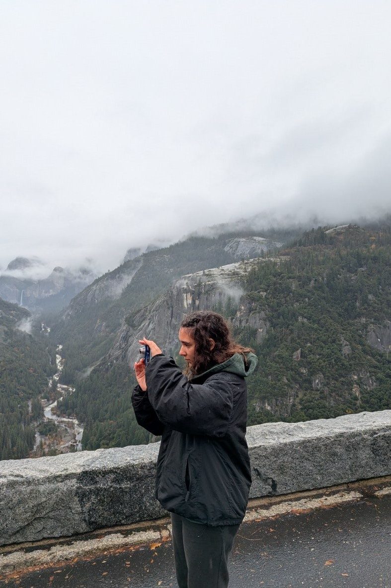 girl taking a photo with waterfall in the background